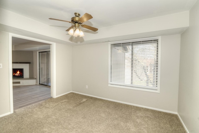 carpeted spare room featuring ceiling fan