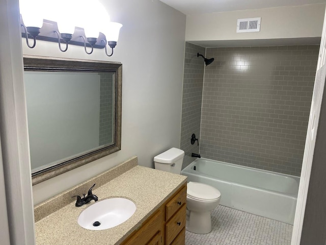 full bathroom featuring tile patterned floors, vanity, tiled shower / bath combo, and toilet