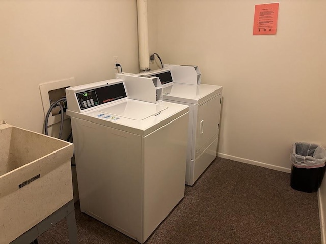 laundry area with sink, dark colored carpet, and independent washer and dryer