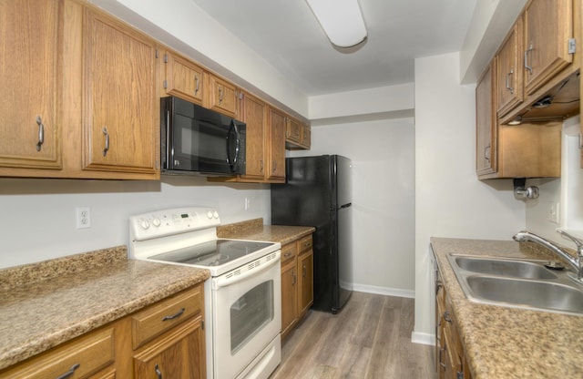 kitchen featuring hardwood / wood-style floors, sink, and black appliances