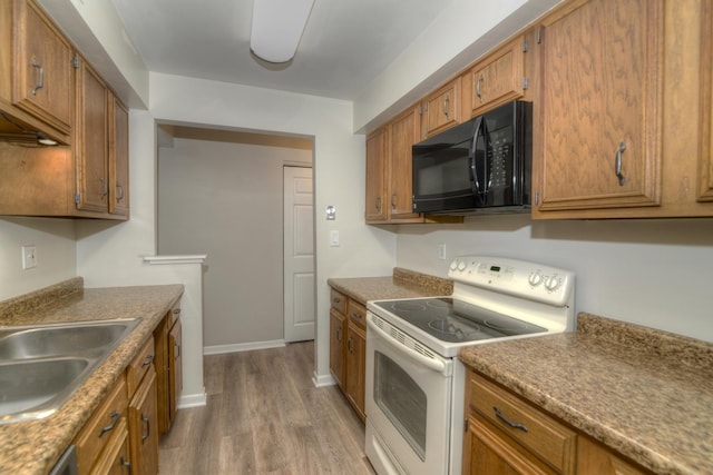 kitchen with white range oven, light hardwood / wood-style flooring, stainless steel dishwasher, and sink