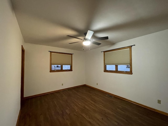 spare room featuring ceiling fan and dark wood-type flooring