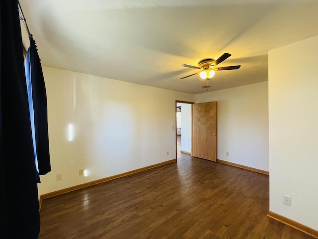 empty room featuring ceiling fan and dark wood-type flooring