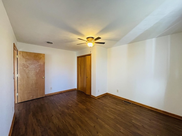 empty room featuring ceiling fan and dark wood-type flooring