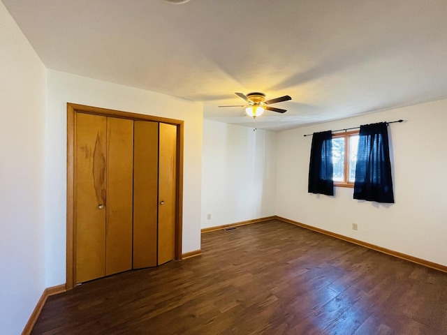 unfurnished bedroom featuring ceiling fan, dark hardwood / wood-style flooring, and a closet