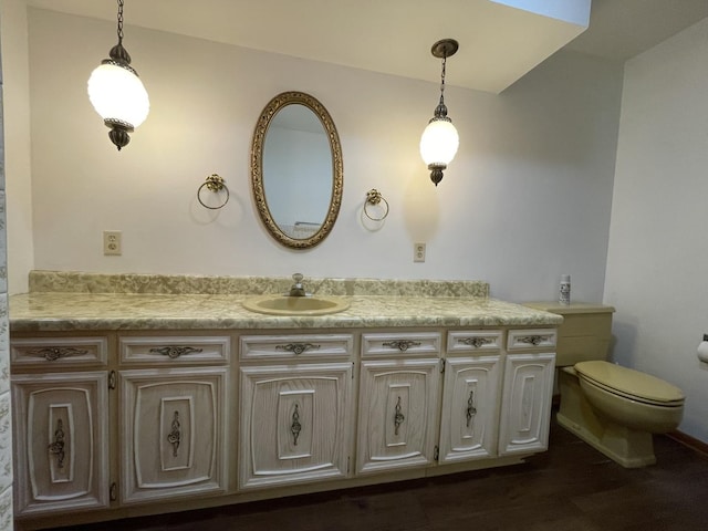 bathroom featuring wood-type flooring, vanity, and toilet