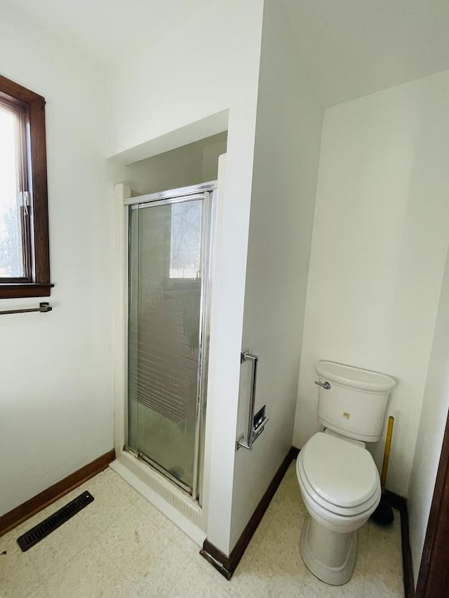 bathroom with toilet and a shower with door