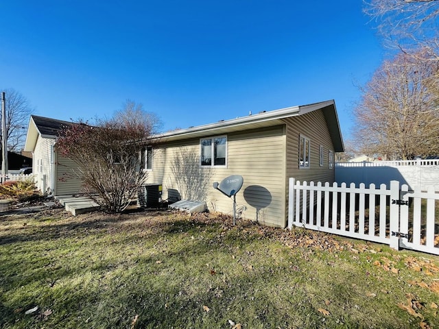 exterior space with a lawn and central AC unit