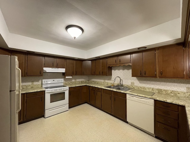 kitchen featuring white appliances, dark brown cabinetry, and sink