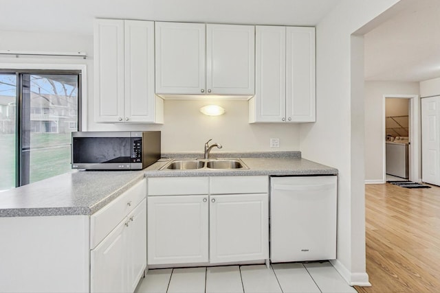 kitchen with white cabinets, sink, washer and dryer, light hardwood / wood-style flooring, and dishwasher