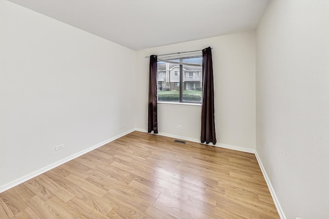 empty room with light hardwood / wood-style flooring