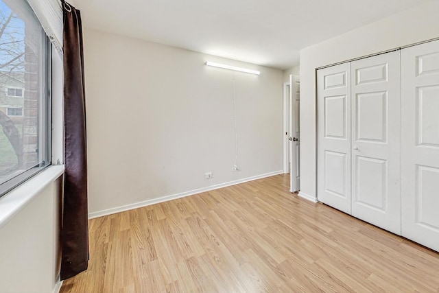 unfurnished bedroom featuring light hardwood / wood-style floors and a closet