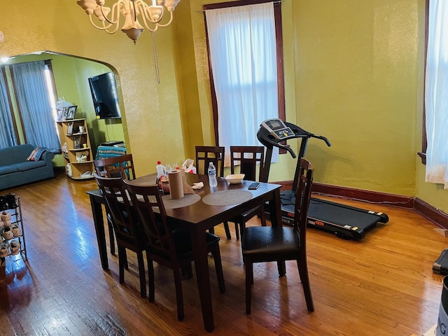 dining space with hardwood / wood-style floors and a chandelier