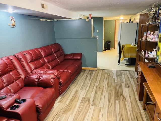 living room with a textured ceiling and light wood-type flooring