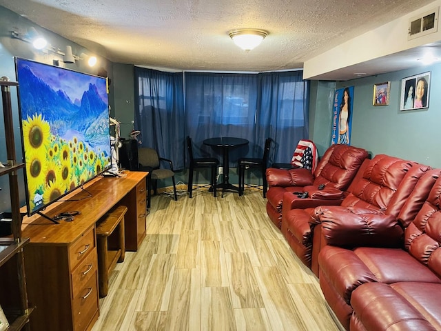 living room featuring a textured ceiling and light wood-type flooring