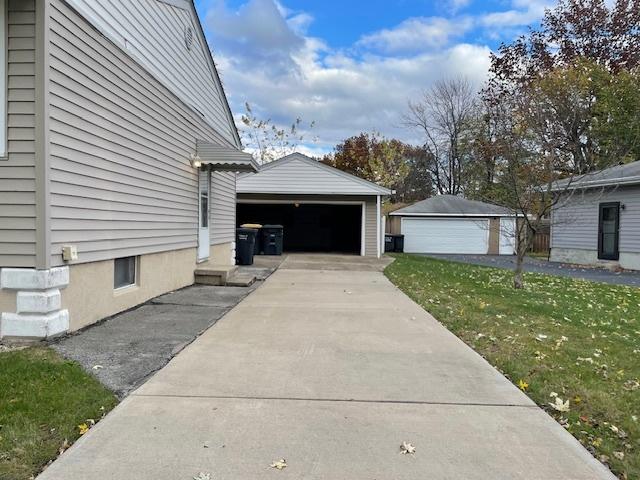 view of side of property featuring a yard, an outbuilding, and a garage