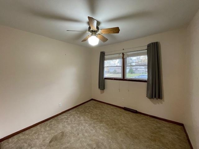 carpeted spare room with ceiling fan