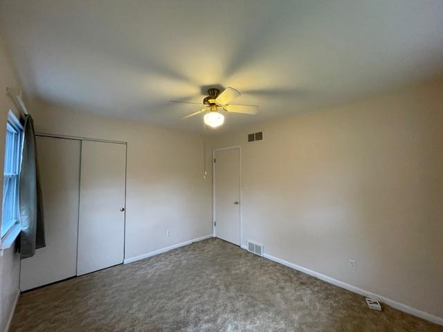 unfurnished bedroom featuring ceiling fan, carpet floors, and a closet