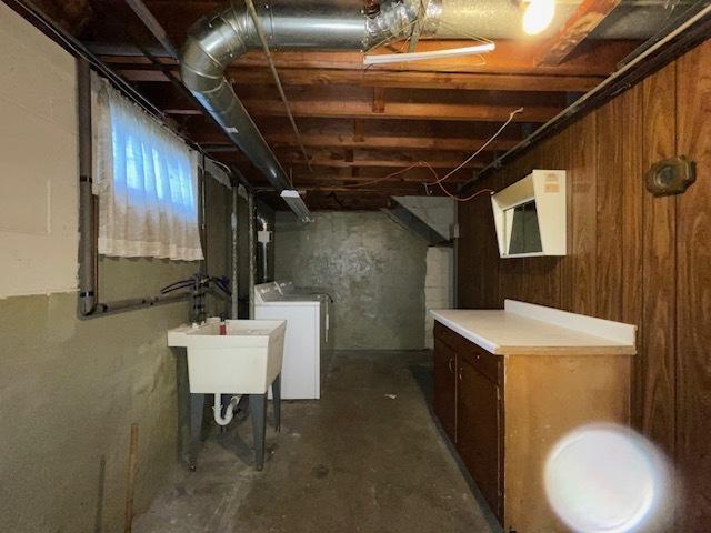 basement featuring separate washer and dryer and sink