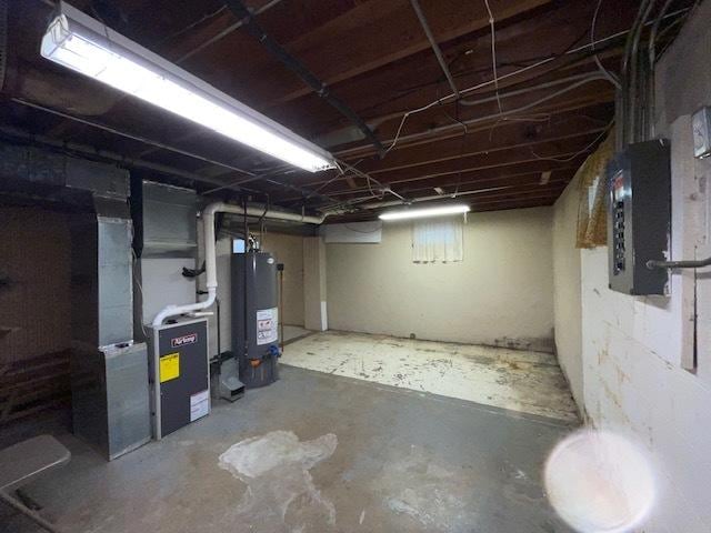 basement featuring gas water heater, electric panel, and heating unit