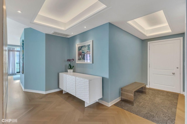 corridor featuring a raised ceiling and parquet floors