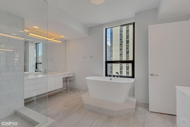 bathroom with separate shower and tub, plenty of natural light, and vanity