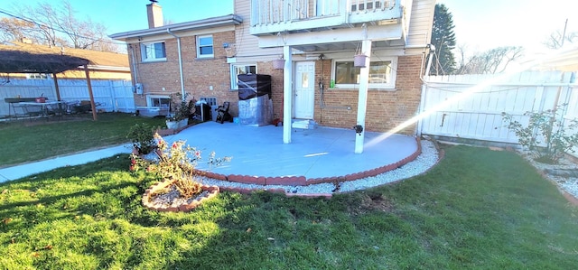 back of house featuring a balcony and a lawn