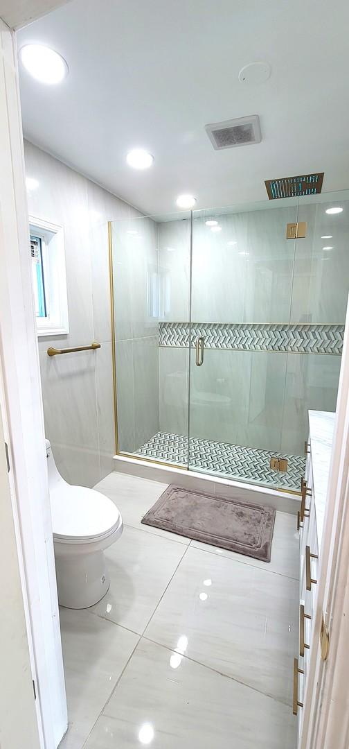 bathroom featuring tile patterned flooring, vanity, toilet, and a shower with door