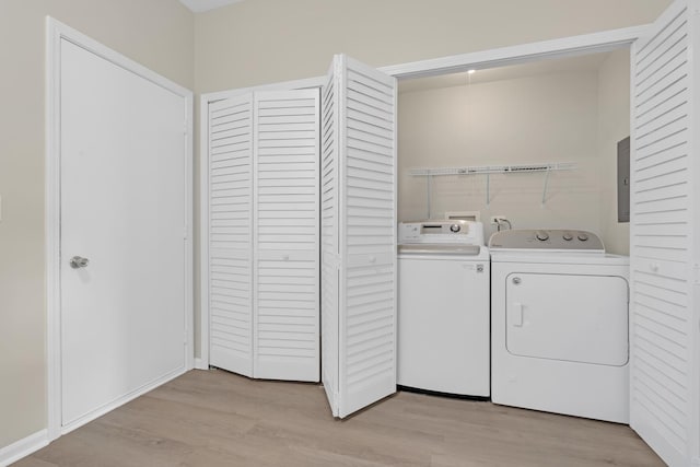 laundry room with separate washer and dryer, light hardwood / wood-style flooring, and electric panel