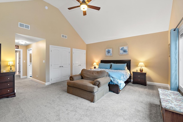 bedroom featuring light carpet, high vaulted ceiling, ceiling fan, and multiple closets