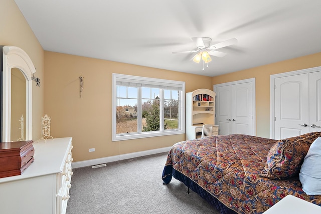 carpeted bedroom featuring two closets and ceiling fan