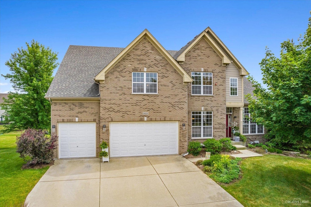 view of front of house with a garage and a front lawn