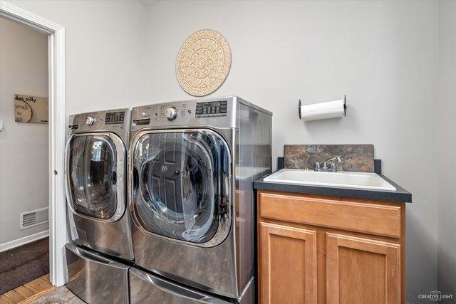 laundry room featuring cabinets, independent washer and dryer, and sink