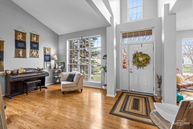 entrance foyer featuring high vaulted ceiling and light wood-type flooring