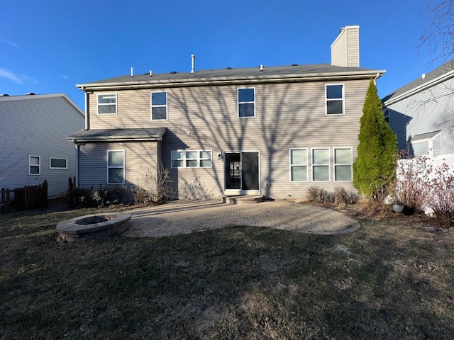 rear view of property with a patio and an outdoor fire pit