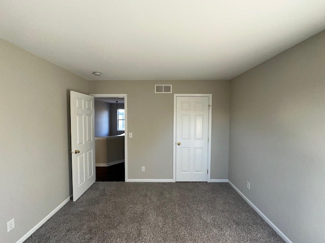 unfurnished bedroom featuring dark carpet