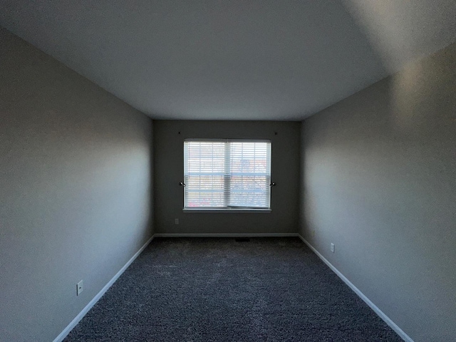 carpeted spare room with lofted ceiling