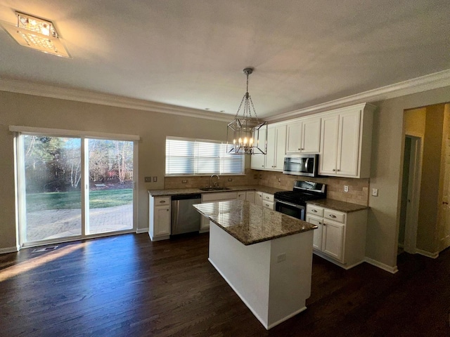 kitchen featuring a center island, sink, dark wood-type flooring, stainless steel appliances, and white cabinets