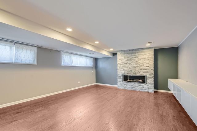 unfurnished living room with recessed lighting, a fireplace, wood finished floors, and baseboards