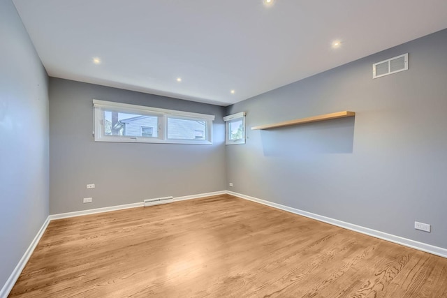 empty room with recessed lighting, light wood-type flooring, visible vents, and baseboards