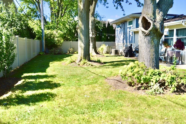 view of yard featuring a fenced backyard and central air condition unit