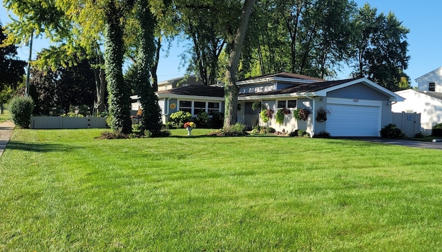 view of front of property with a garage, driveway, a front lawn, and fence