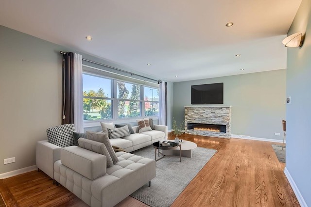 living area with recessed lighting, a fireplace, baseboards, and wood finished floors