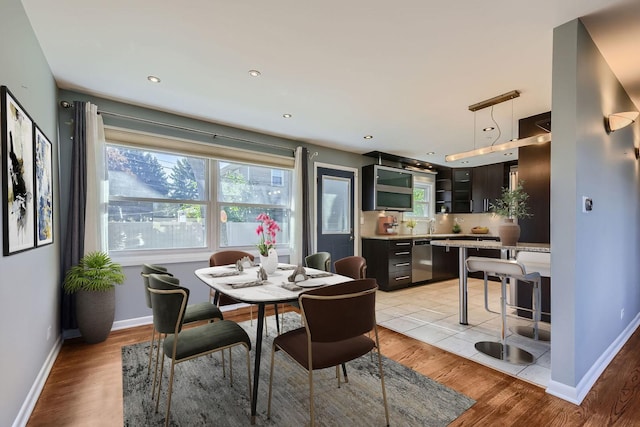 dining area with a wealth of natural light, baseboards, and light wood finished floors