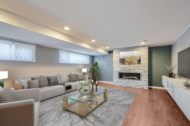 living area with a fireplace, baseboards, wood finished floors, and recessed lighting