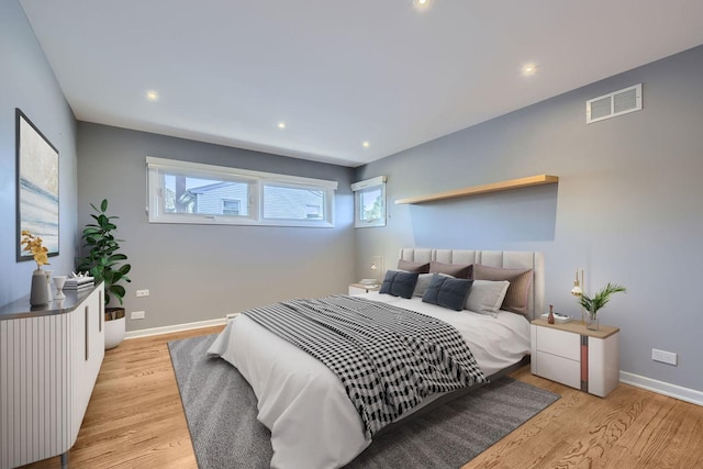 bedroom featuring light wood-type flooring, visible vents, baseboards, and recessed lighting