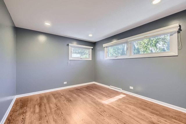 spare room featuring light wood-type flooring, visible vents, baseboards, and recessed lighting