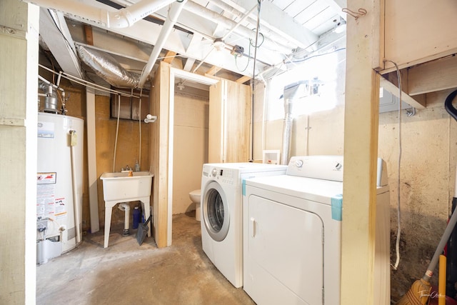 clothes washing area with separate washer and dryer and gas water heater