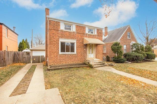 view of front of home featuring a front yard, a garage, and an outdoor structure