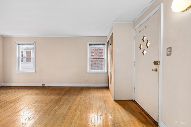 foyer entrance featuring crown molding, plenty of natural light, and light hardwood / wood-style flooring